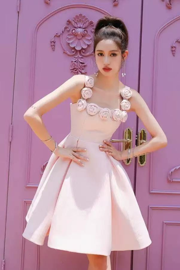 Woman in a pink dress standing in front of a decorative purple door